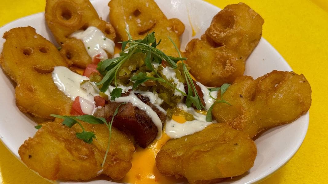 Evil Minion Totchos Relaxing in a ‘Tot Tub’ Might Be the Funniest Theme Park Food We’ve Ever Had